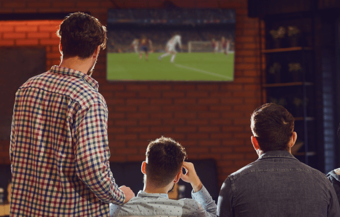 Clientes viendo un partido de fútbol en directo en un bar equipado con Orange TV Bares.